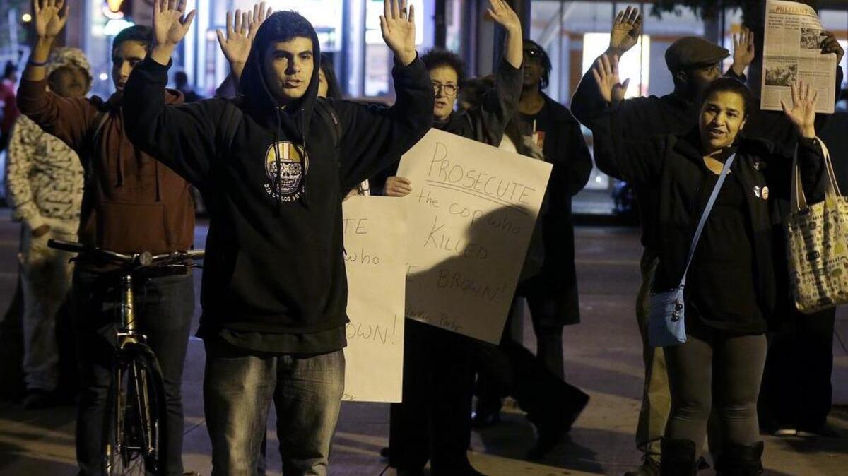 People raise their arms while chanting “Hands Up, Don’t Shoot” during a protest after a grand jury had decided not to indict Ferguson, Mo., police officer Darren Wilson in the fatal shooting of Michael Brown, an unarmed black 18-year-old.