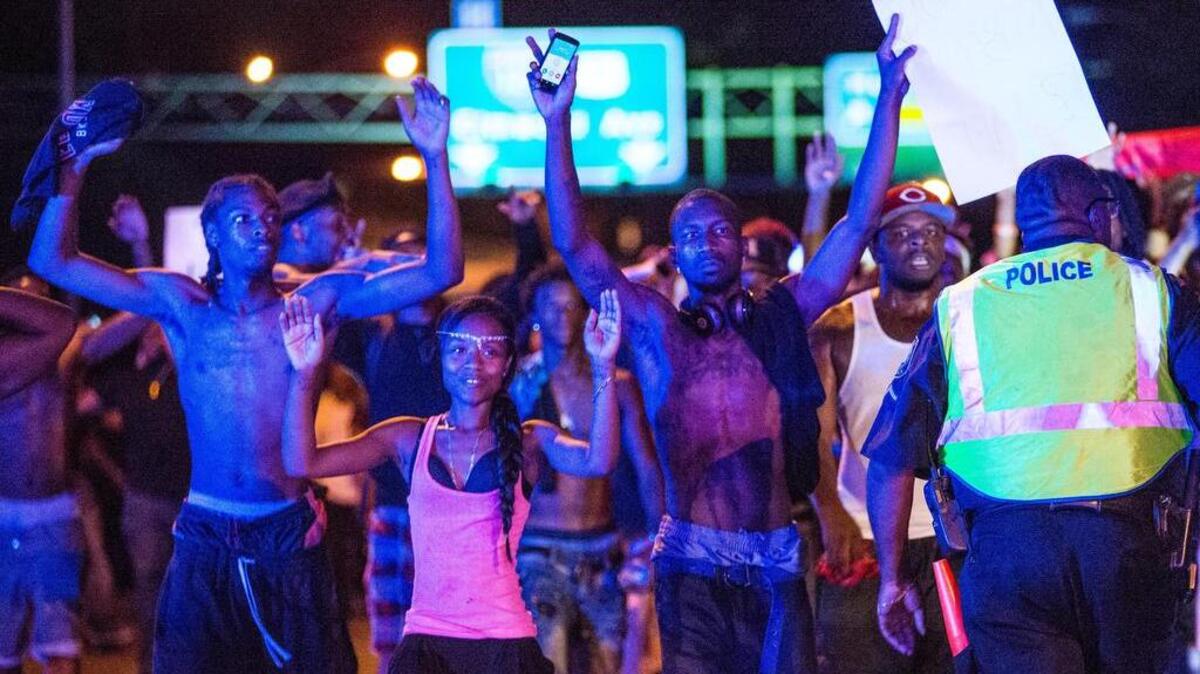 Protestors walk with their hands up where Huger Street becomes Interstate 126 during a July 10 rally and march in Columbia.