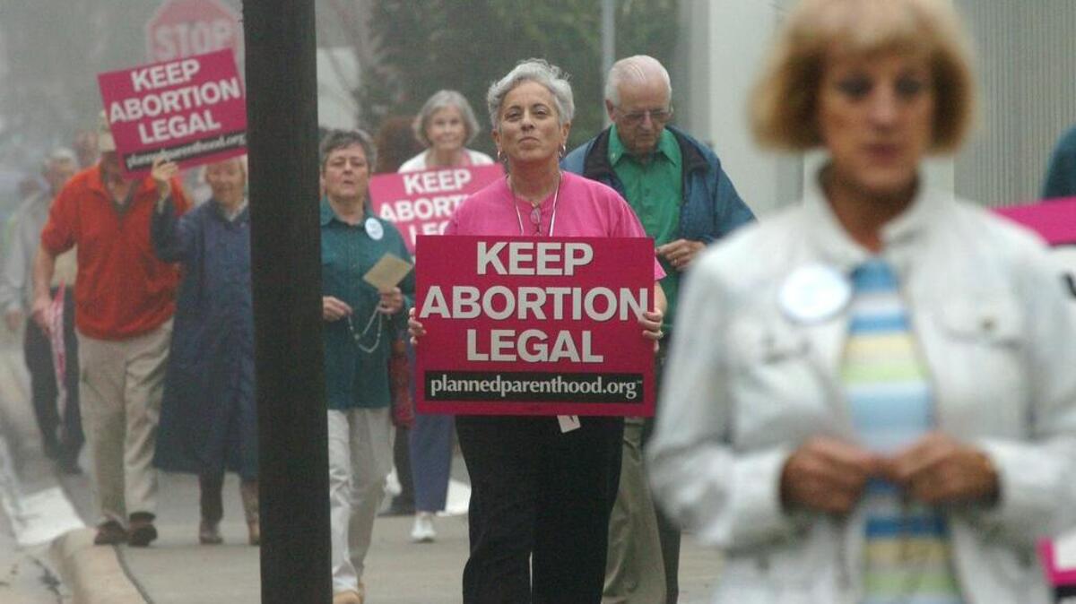 GRANT JEFFERIES/gjefferies@bradenton.com  
Pro-Choice and Pro-Life demonstrators mingled together as they both circled the Planned Parenthood regional office in Sarasota Friday morning marking the 37th anniversary of the U.S. Supreme Court ruling on abortion rights.  
