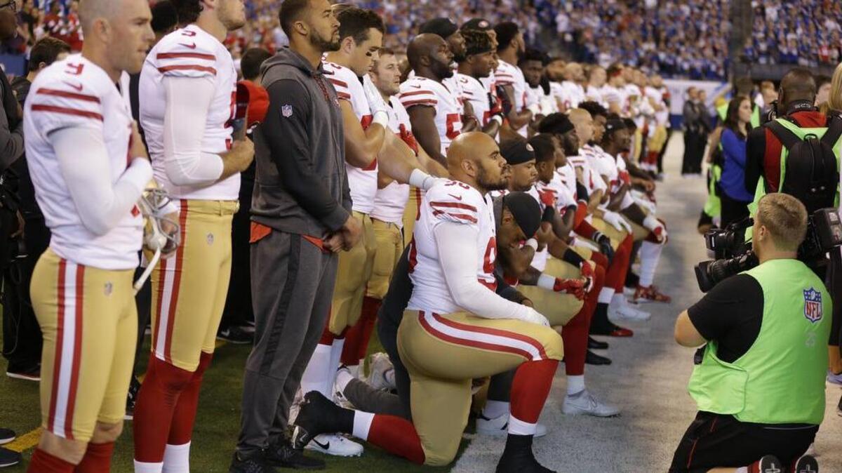 Member of the San Francisco 49ers kneel during the national anthem before an NFL football game against the Indianapolis Colts.