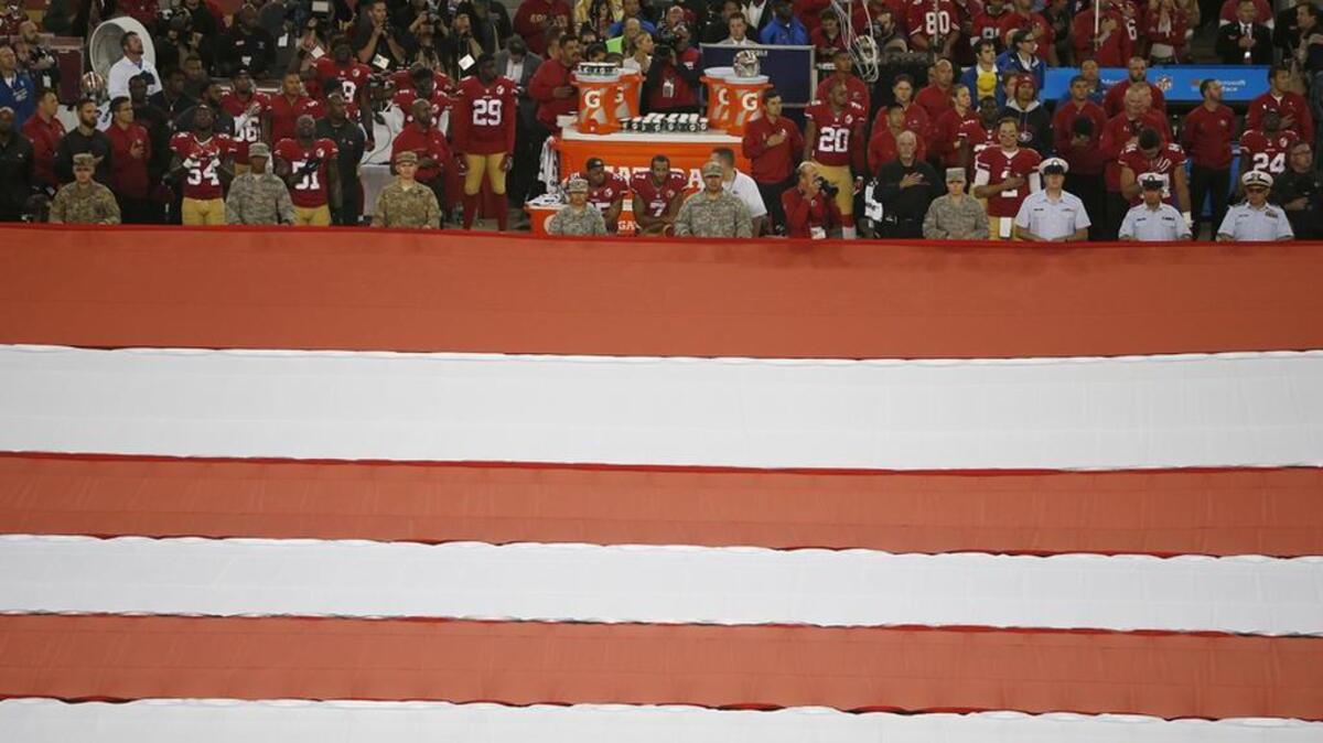 San Francisco 49ers safety Eric Reid and quarterback Colin Kaepernick kneel during the national anthem before an NFL football game.