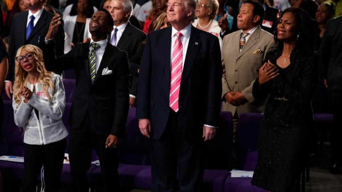 Republican presidential candidate Donald Trump, center, looks on during a church service at Great Faith Ministries Saturday in Detroit.