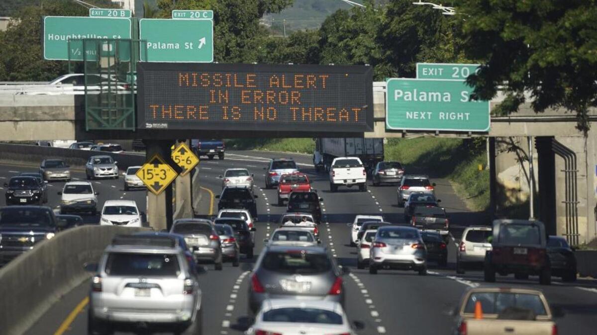 In this Jan 13 photo provided by Civil Beat, cars drive past a highway sign posted on the H-1 Freeway in Honolulu. The state emergency officials announced human error as cause for a statewide announcement of an incoming missile strike alert that was sent to mobile phones.