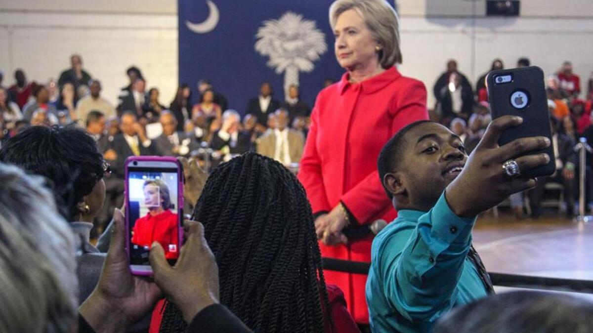 Fans shoot photos as Hillary Clinton speaks at Denmark-Olar Elementary School earlier this month.
