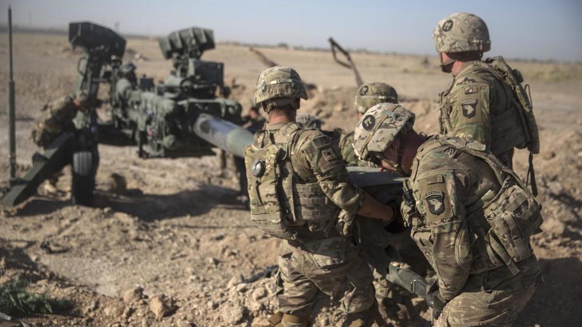 In this June 10, 2017 photo provided by Operation Resolute Support, U.S. Soldiers with Task Force Iron maneuver an M-777 howitzer, so it can be towed into position at Bost Airfield, Afghanistan.