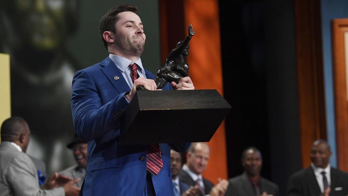Oklahoma quarterback Baker Mayfield holds up the Heisman Trophy after winning the award on Dec 9.