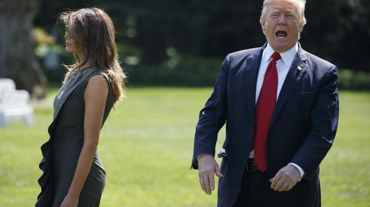 President Donald Trump shouts to reporters as he walks with first lady Melania Trump to board Marine One on Friday.