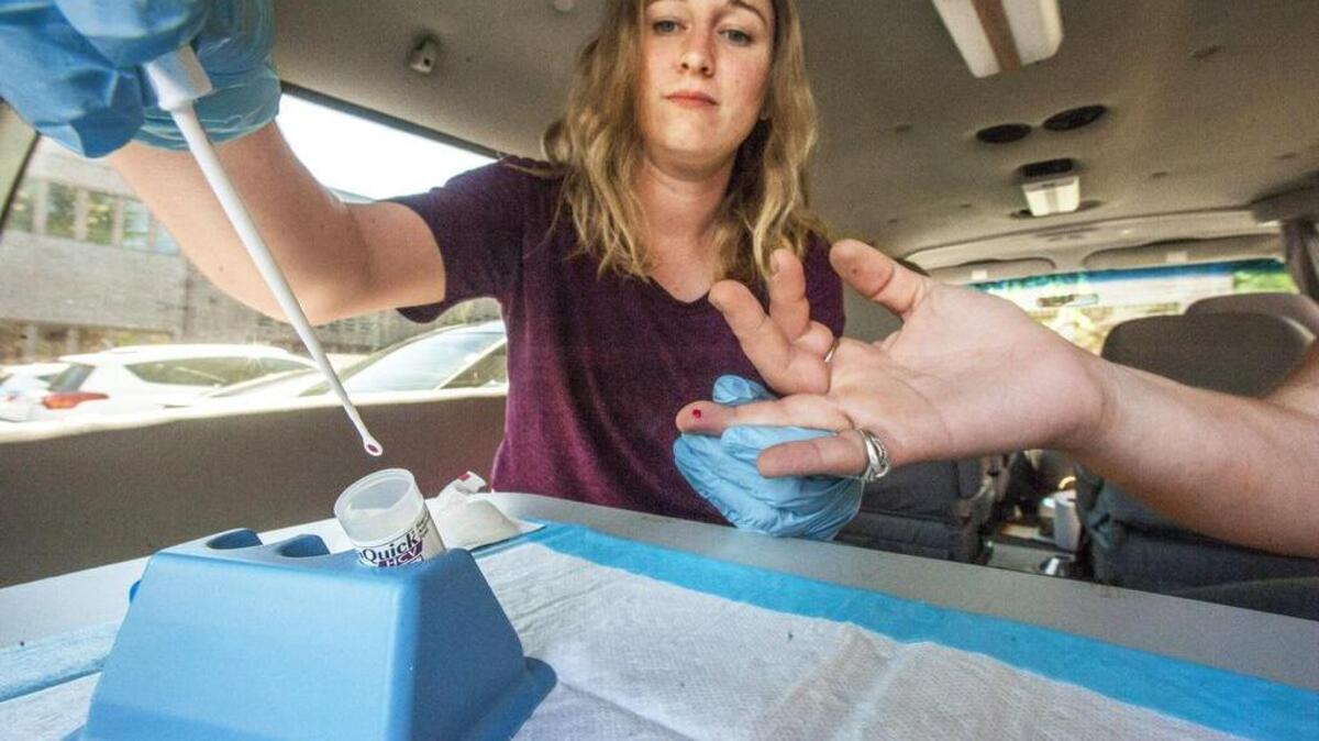 Community outreach worker Madeline Meisburger with the Tacoma Needle Exchange tests a needle user for possible exposure to Hepatitis C, August 10, 2016.