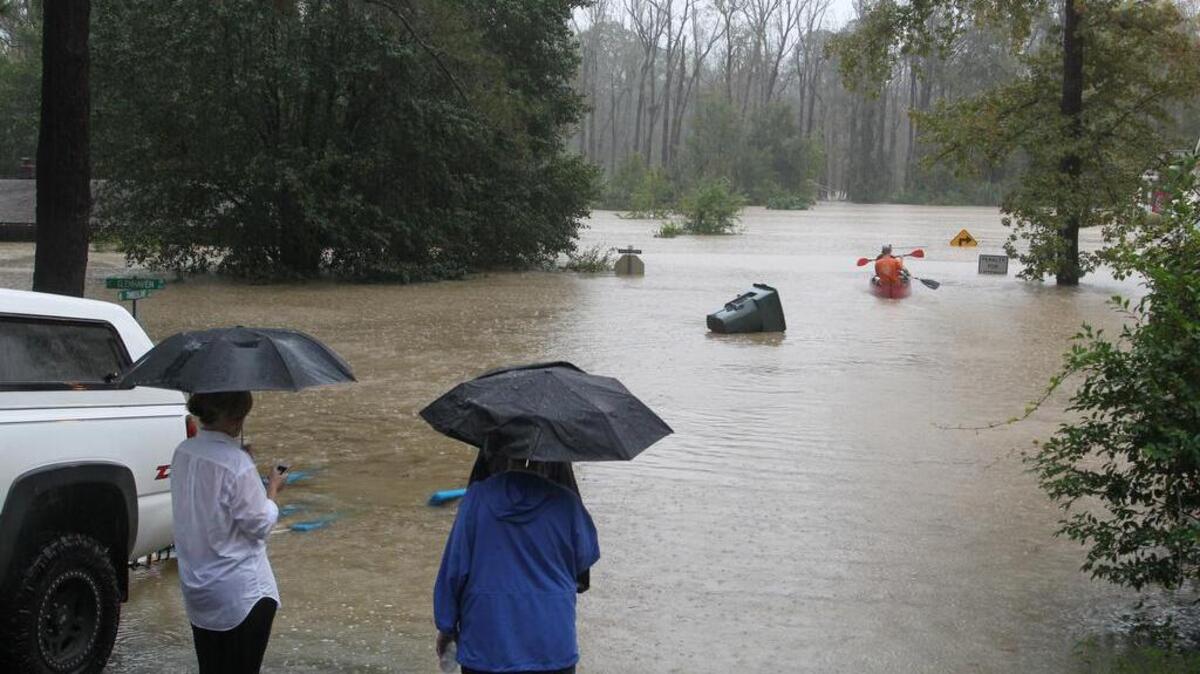 
Neighbors watch as John Wienges and Will Lenski rescue their neighbors from their flooded homes along Gills Creek. The river flooded homes along Timberlane Drive and Whispering Pines Circle in Columbia.
