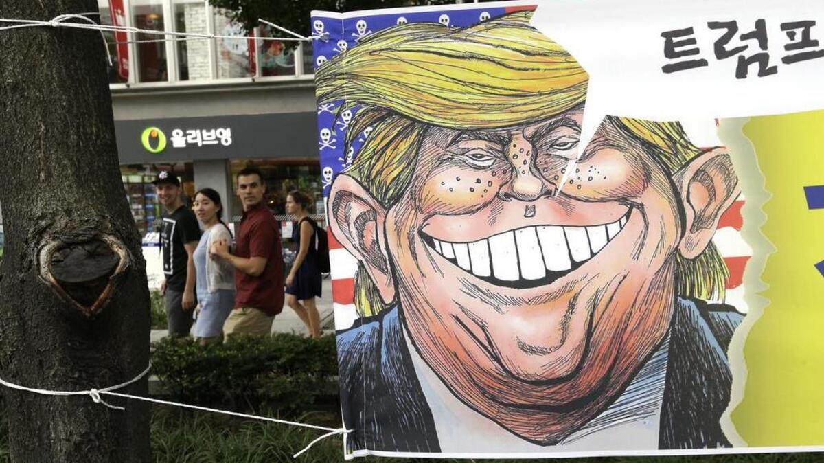 A banner with an illustration of President Donald Trump is displayed to oppose his war rhetoric on North Korea, on a street in Seoul, South Korea.