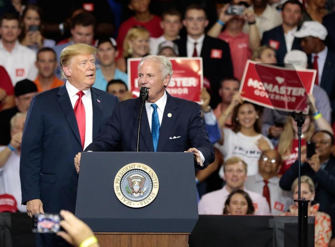 President Donald Trump, right, listens as South Carolina Gov. Henry McMaster speaks at Airport High School on Monday, June 25, 2018, in West Columbia, South Carolina. (Tracy Glantz/The State)