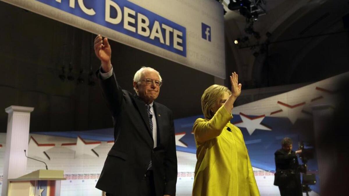 Democratic presidential candidates Sen. Bernie Sanders and Hillary Clinton take the stage before a Democratic presidential primary debate earlier this month.