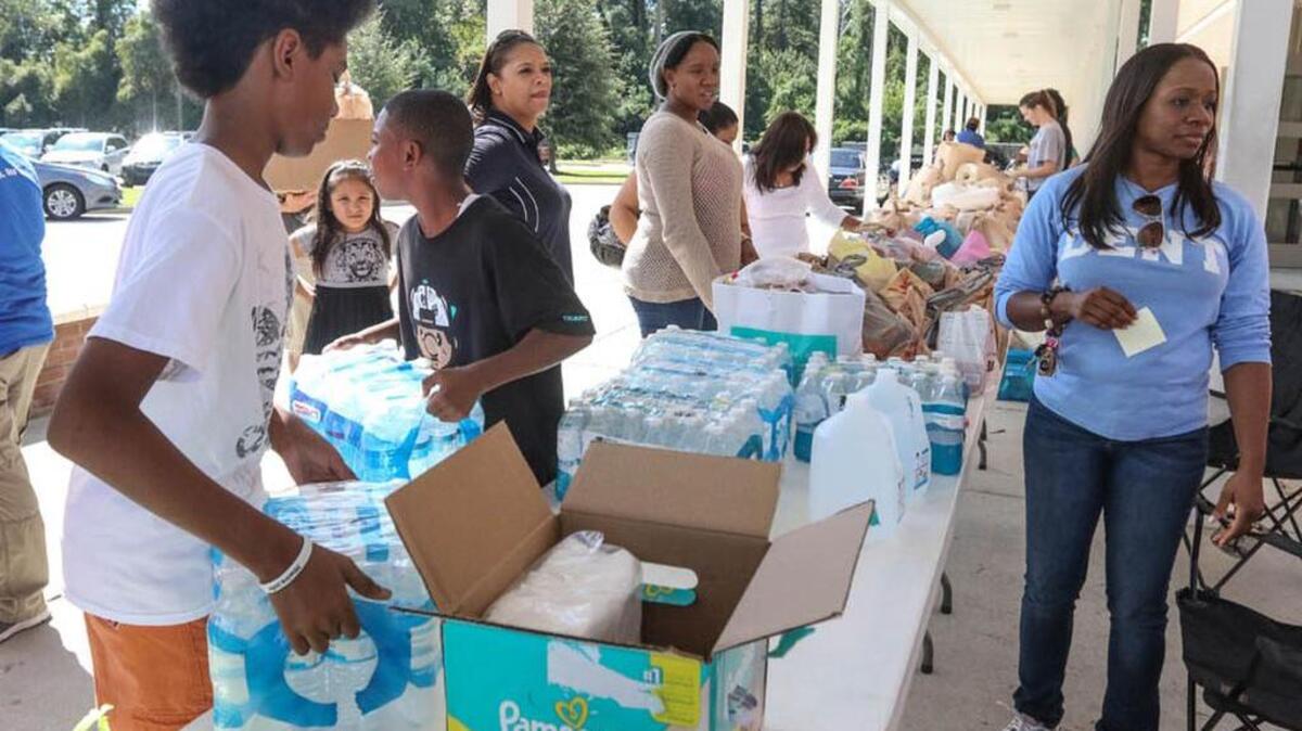 Students help sort donated items at Dent Middle School after the floods.