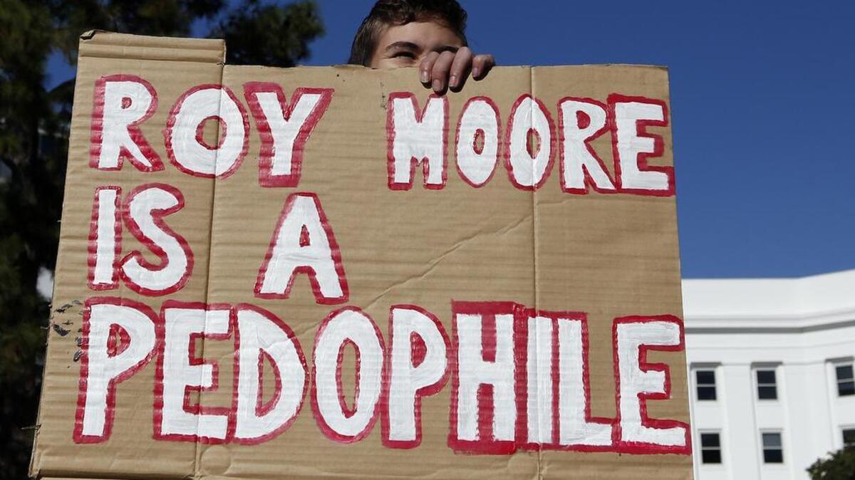 Rose Falvey of Montgomery, stands outside the Alabama State Capitol in protest against former Alabama Chief Justice and U.S. Senate candidate Roy Moore, as Moore's wife, Kayla Moore, speaks at a news conference last week.