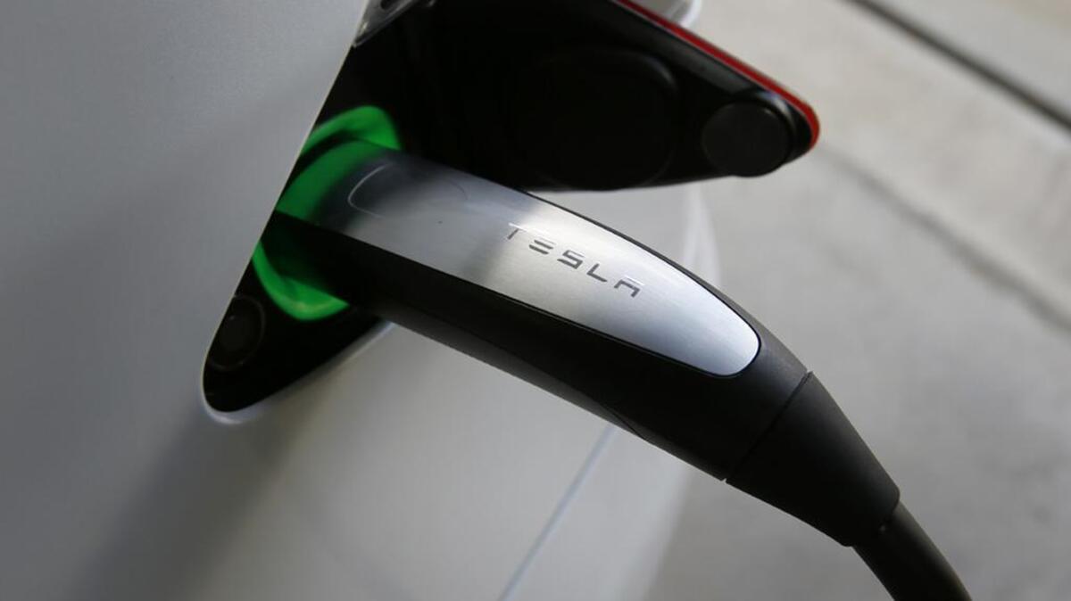 A charging cable is attached to a Tesla Model S vehicle.