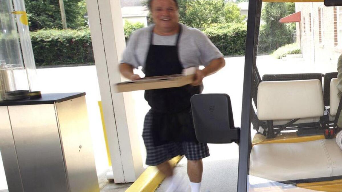Pizza Man owner Paul Whitlark delivers a pizza in this 2008 photo.