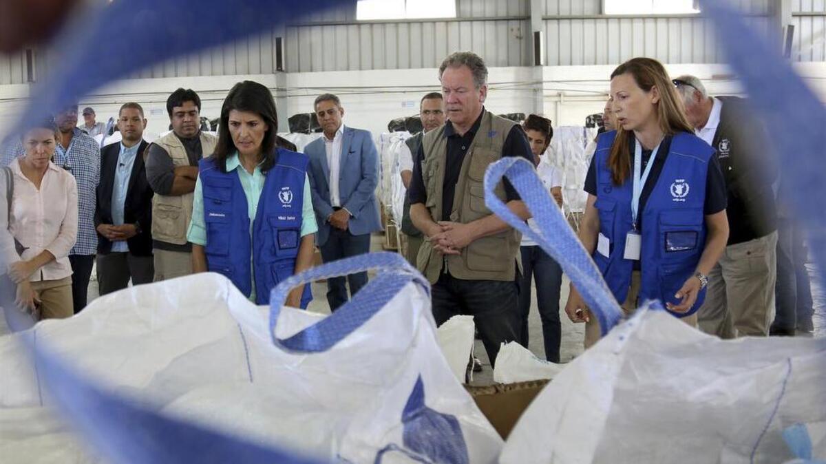 U.S. Ambassador to the United Nations Nikki Haley, center left, and World Food Program director David Beasely, center, inspect a food pallet to be air-dropped deep inside Syria.