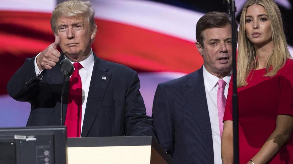 In this photo taken July 21, 2016, then-Trump campaign manager Paul Manafort stands between the then-Republican presidential candidate Donald Trump and his daughter Ivanka Trump during a walk-through at the Republican National Convention in Cleveland.