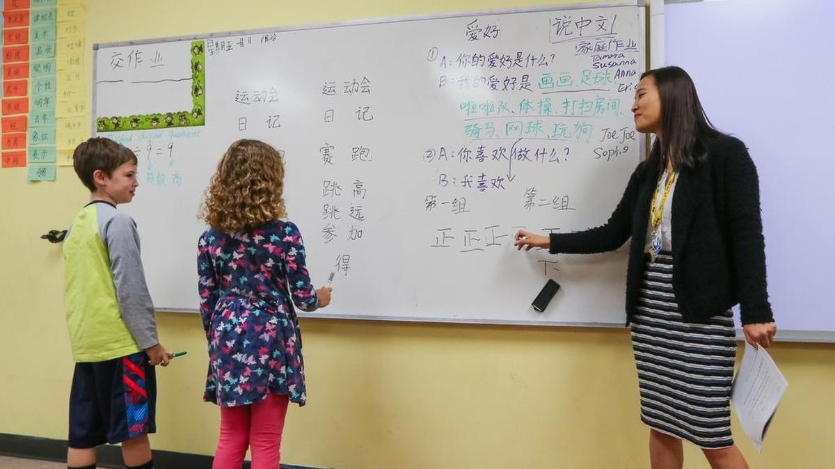 Fourth-grade teacher Lige Zhao quizzes Beckham O’Neil and Kasiah Hart on their Mandarin language skills at East Point Academy, a Chinese immersion charter school in West Columbia.
