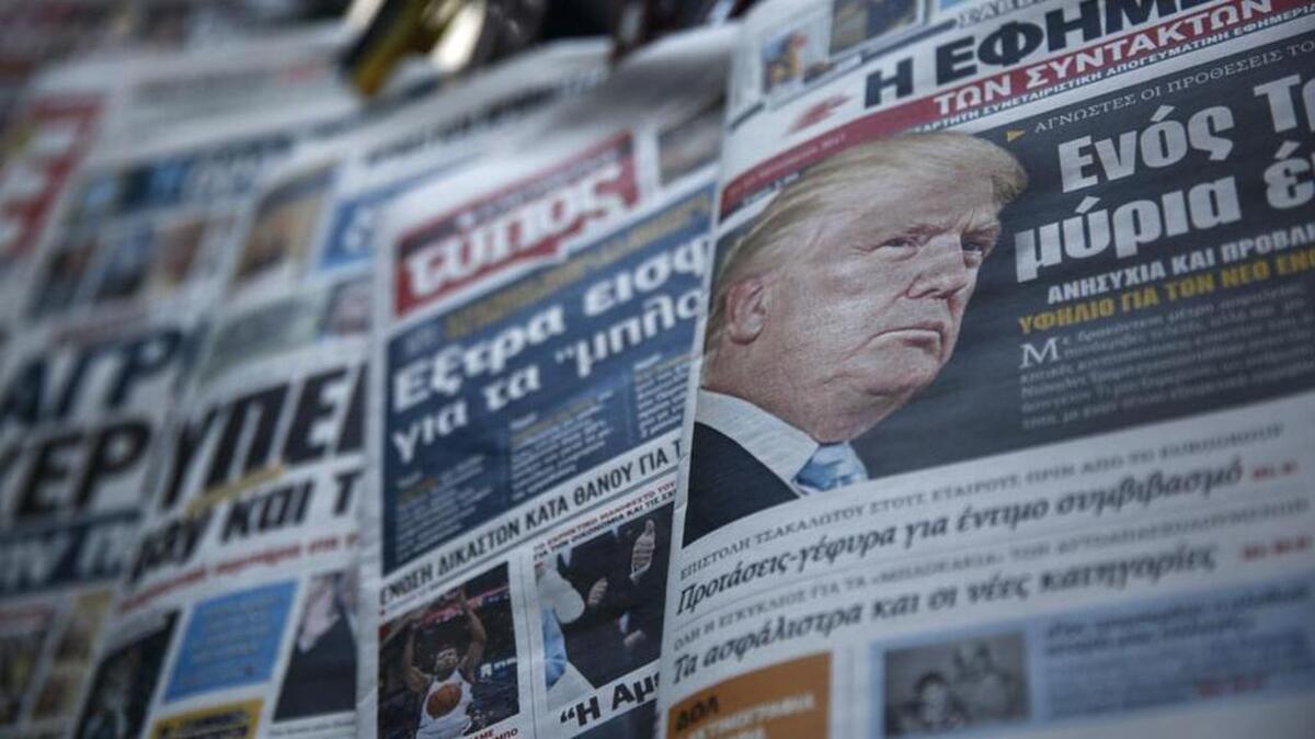 A front page of a Greek daily newspaper featuring a portrait of US President Donald Trump is on display outside a kiosk in Athens after he promised an “America first” policy in his inaugural address.