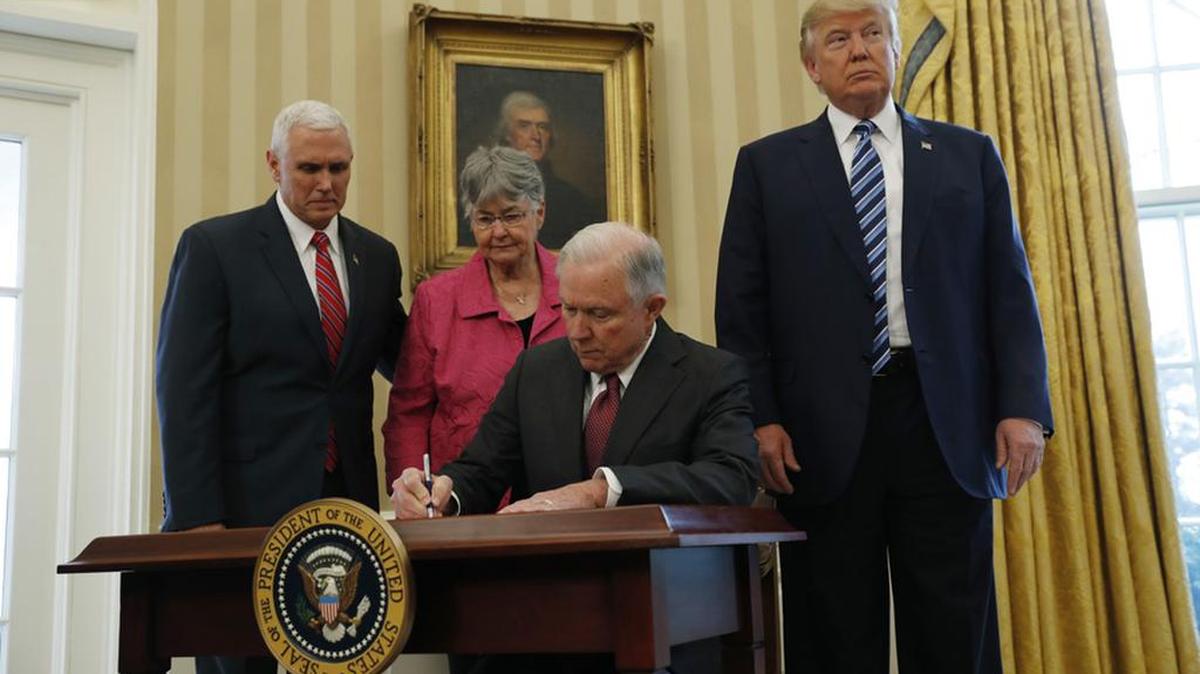Attorney General Jeff Sessions signs an affidavit of appointment after being sworn-in as attorney general in February. With him are Vice President Mike Pence, Mary Sessions and President Donald Trump.