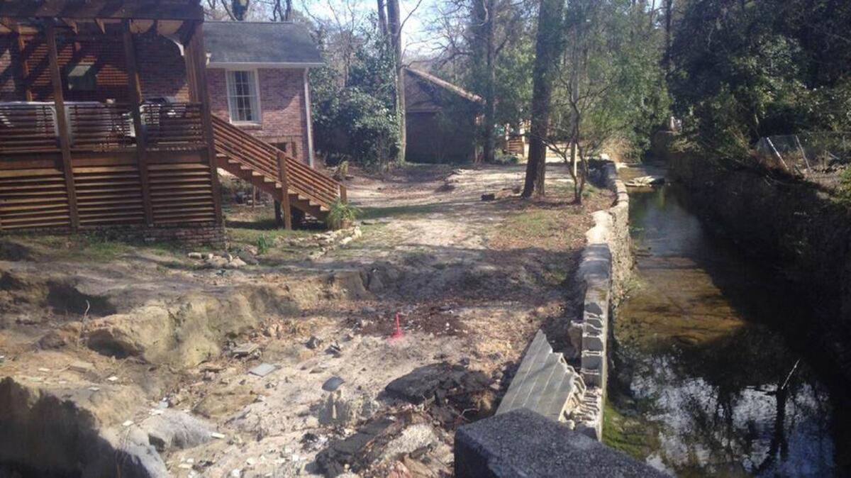 Even where houses are being repaired, yards such as these along Penn Branch still bear the marks of the October floods.