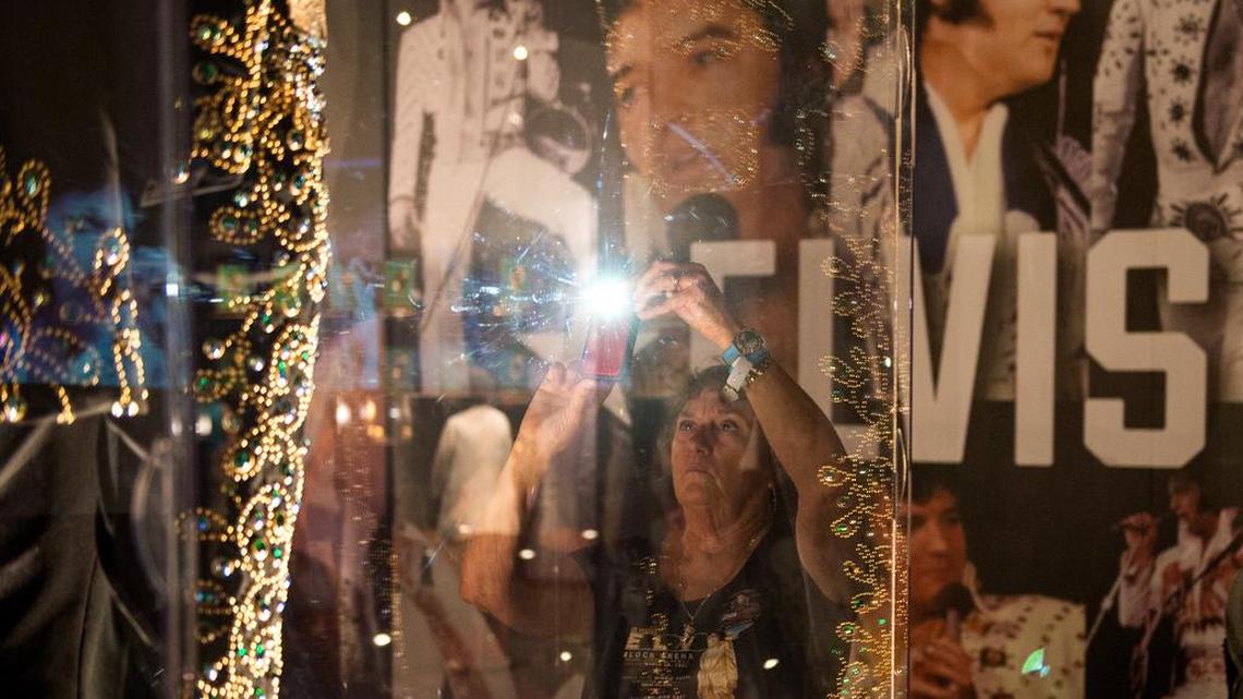 Colorado resident Vera Van Lew photographs a performance outfit worn by Elvis Presley at an exhibit in Graceland, Presley’s Memphis home, on Tuesday, the eve of the 40th anniversary of his death.