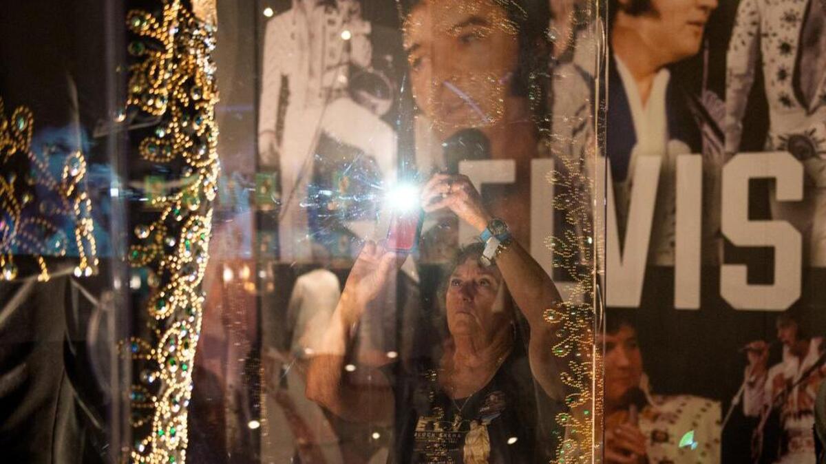 Colorado resident Vera Van Lew photographs a performance outfit worn by Elvis Presley at an exhibit in Graceland, Presley’s Memphis home, on Tuesday, the eve of the 40th anniversary of his death.