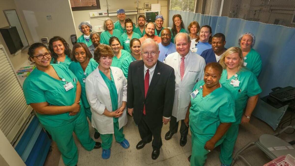 
Former Columbia Bob Coble poses in the room where he recovered, along with the Providence Hospital medical team he credits with saving his life after a major heart attack earlier this year.

