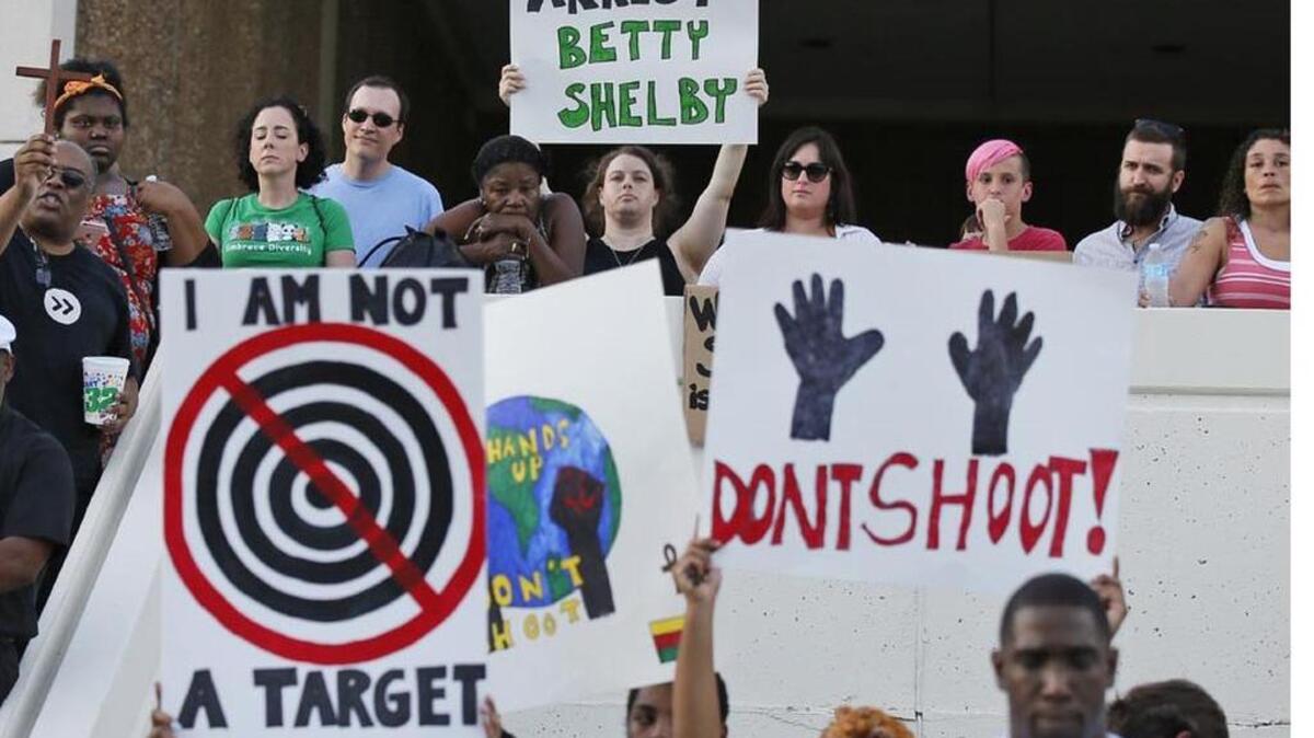People hold signs at a “protest for justice” over last week’s shooting death of Terence Crutcher by a Tulsa police officer.