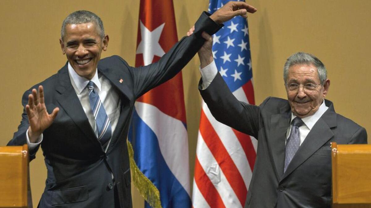 Cuban President Raul Castro lifts up the arm of President Barack Obama at the conclusion of their joint news conference in Havana on Monday.