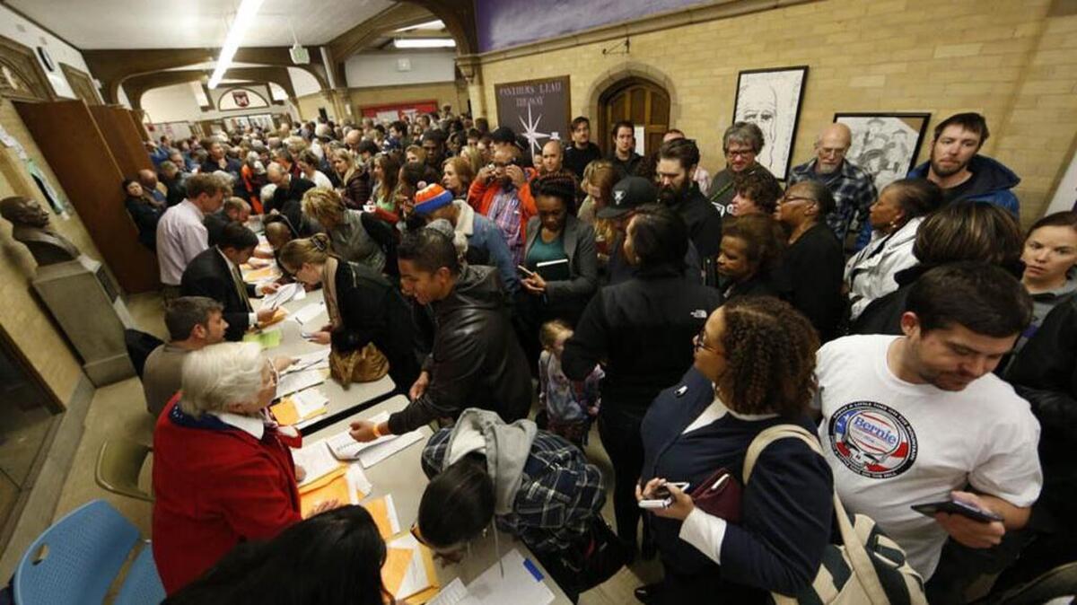 Voters crowd into foyer of Smiley Middle School to check in with their precinct captains to attend a Denver Democratic caucus on Tuesday.