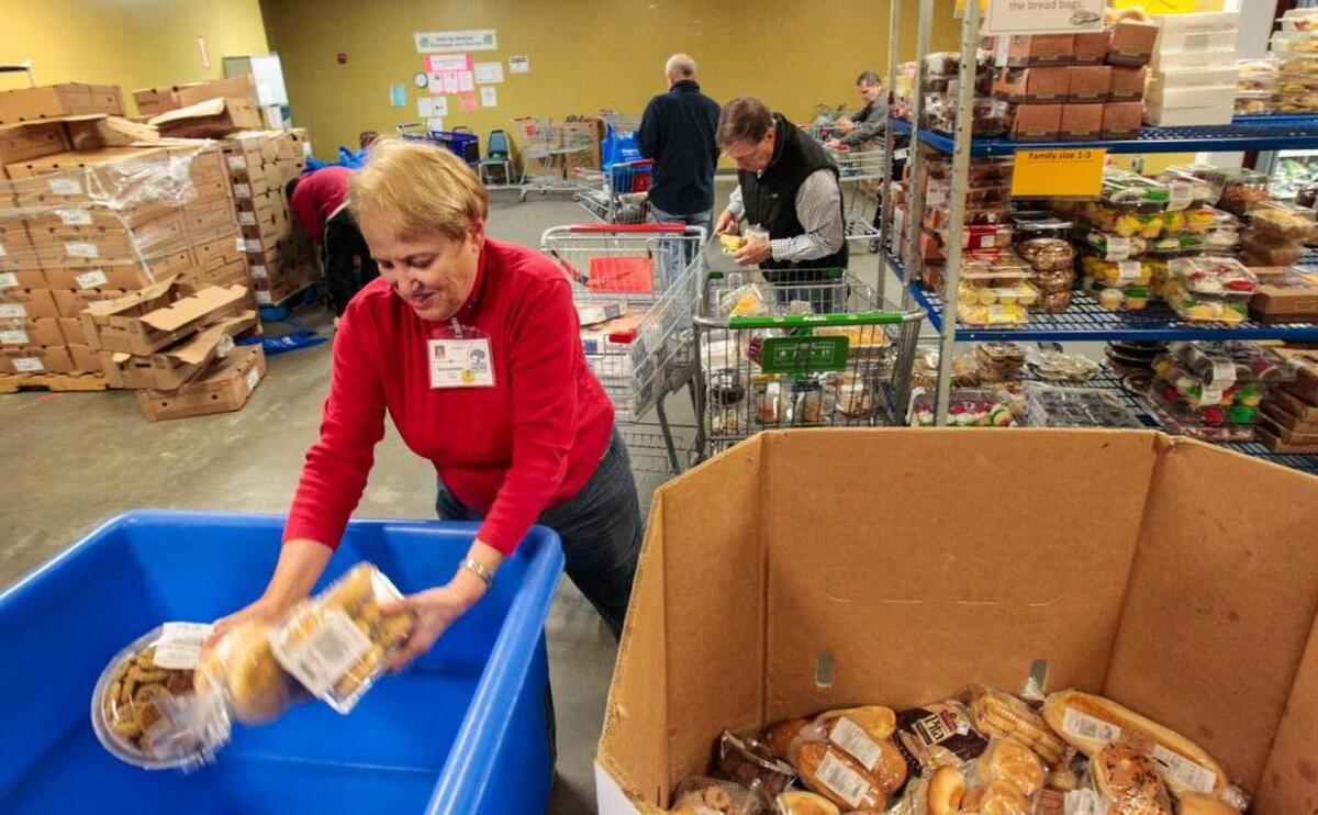 
Volunteers at Harvest Hope Food Bank gather food for a line of people in need who came to get food for Christmas. Harvest Hope is among scores of local charities that will participate in Tuesday’s Midlands Gives campaign.
