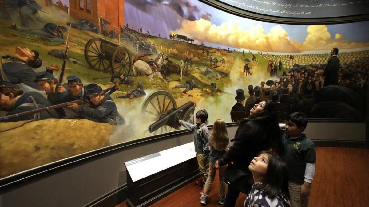 Visitors view the Gettysburg Address and battle mural at the Abraham Lincoln Presidential Museum and Library.
