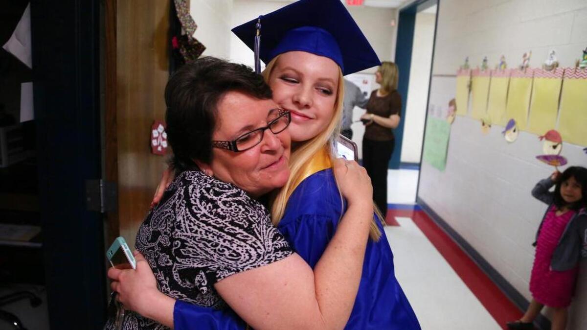 Springdale Elementary teacher Geloris Baxley hugs Lily Leaphart during a May event that encouraged Airport High School graduating seniors to return to their elementary schools to walk the halls one final time.