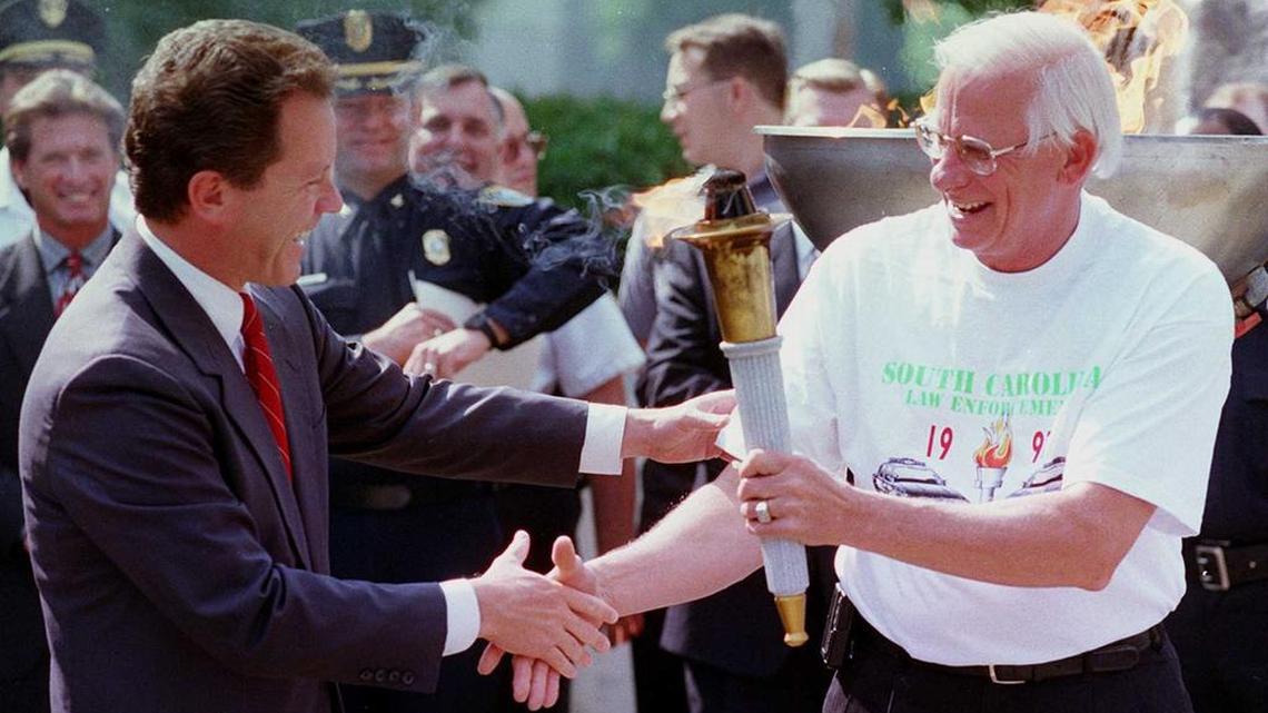 Then-SC Gov David Beasley hands off the Special Olympics torch to his Corrections Department director, Michael Moore, in this 1997 photo. Moore died on Tuesday.