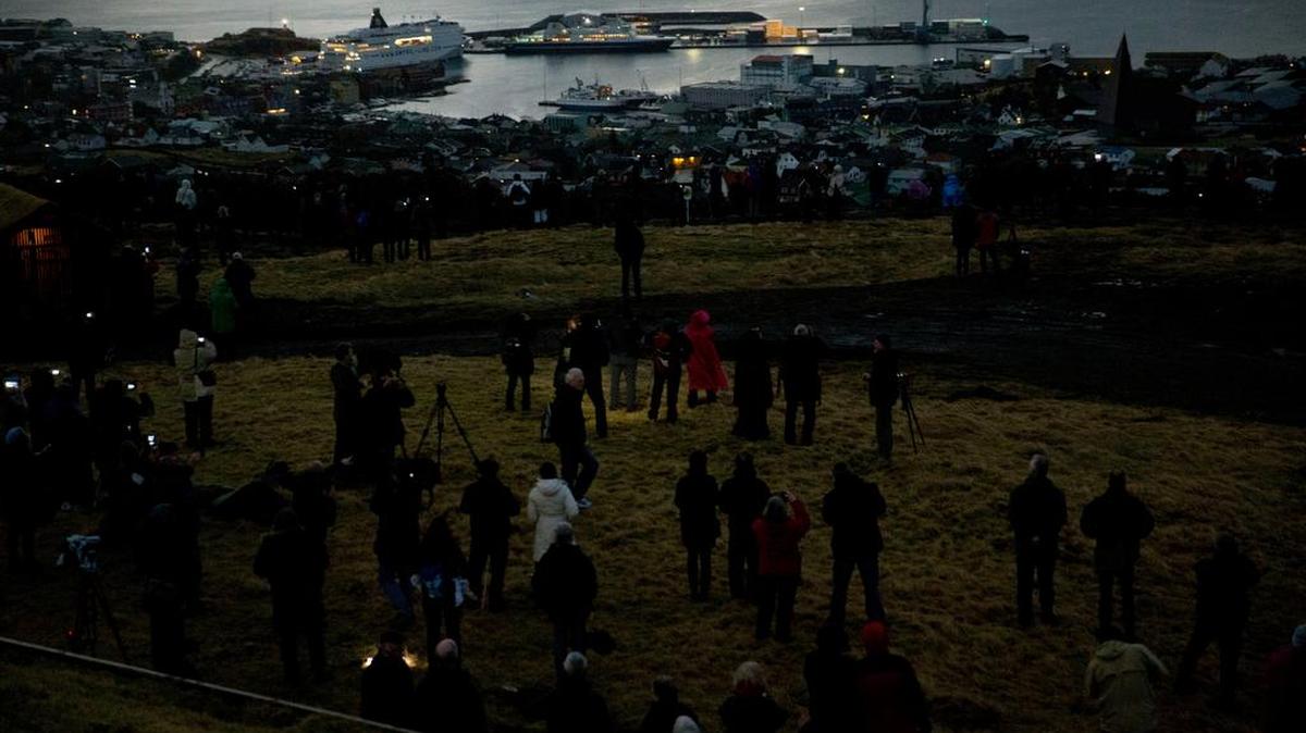 People watch from a hill overlooking Torshavn, the capital city of the Faeroe Islands, as darkness falls during the March 20, 2015, solar eclipse. McClellanville (well, along with Charleston) could be the U.S. Torshavn next month.