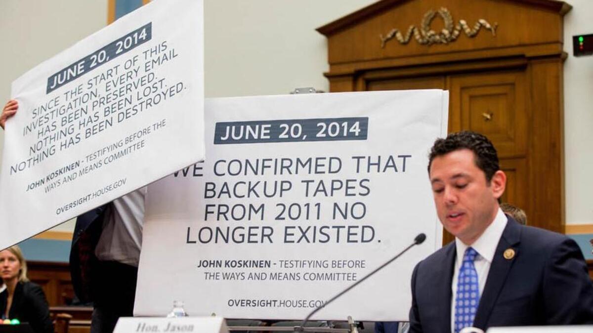 A staff member displays posters depicting quotes from IRS Commissioner John Koskinen as Rep. Jason Chaffetz, R-Utah, testifies before the House Judiciary Committee hearing in May on allegations of misconduct against Koskinen. (AP Photo/Andrew Harnik)