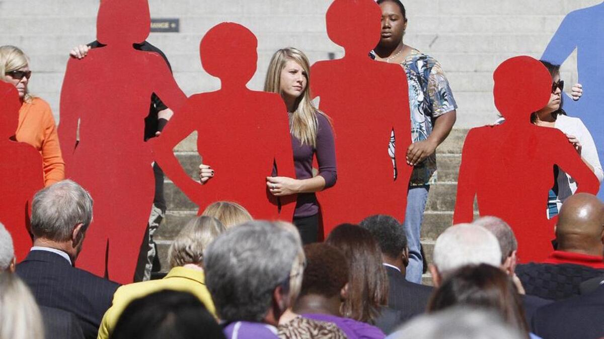 Presenters hold silhouettes representing victims of domestic violence at the annual SC Silent Witness ceremony.