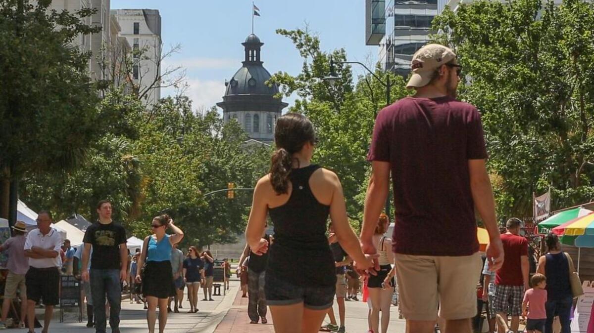 People walk along Columbia’s Main Street during Soda City Market.