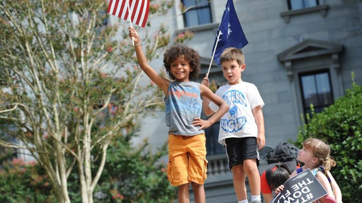
Chance Ashcraft, 8, of Irmo joined Rayan Boutahar, 5, and Vivian Green, 5, both of Columbia on the SC State House grounds during an anti-Confederate flag rally.
