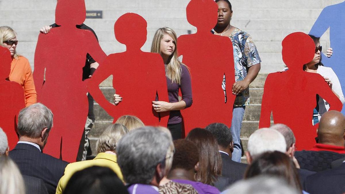 
Presenters hold silhouettes representing SC victims of domestic violence during the 2014 South Carolina Silent Witness Story ceremony.
