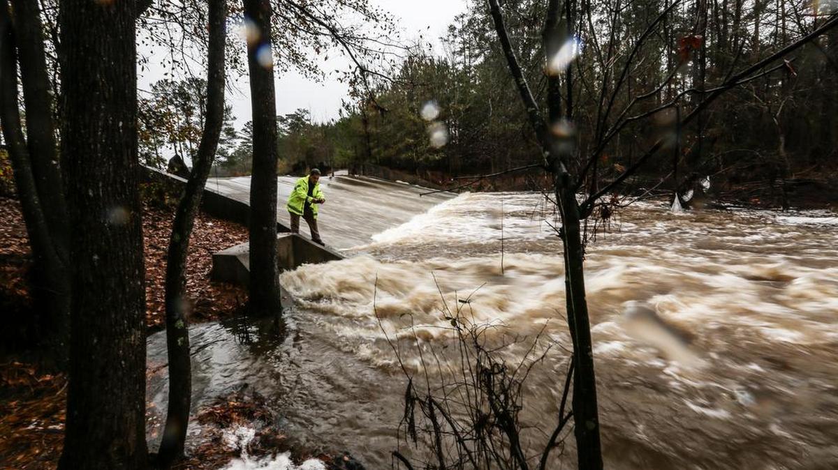 With stormwater-storage capacity lost due to dam breaches, it doesn’t take an October-sized event to cause flooding. Here, a DHEC dam inspector looks over a dam in December after heavy rains filled the lake and caused it to spill over the top.