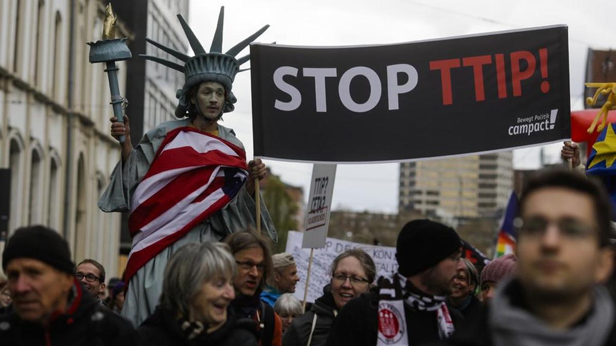 A man on stilts and dressed like the Statue of Liberty holds a banner with the slogan Stop TTIP during a protest of thousands of demonstrators against the planned Transatlantic Trade and Investment Partnership ahead of the visit of President Barack Obama in Hannover, Germany, in April. Anti-trade sentiment is growing globally and could upend US politics.