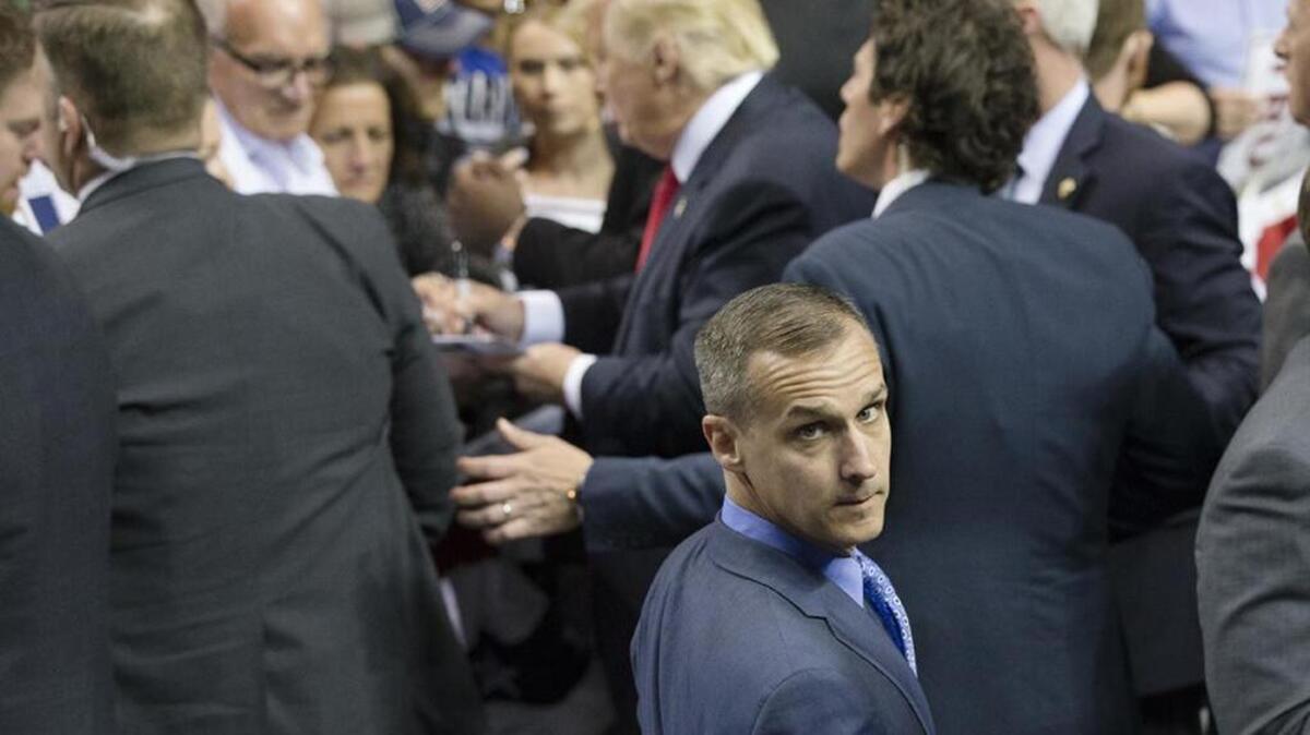 Then-campaign manager Corey Lewandowski walks a rope line as Donald Trump signs autographs in April.