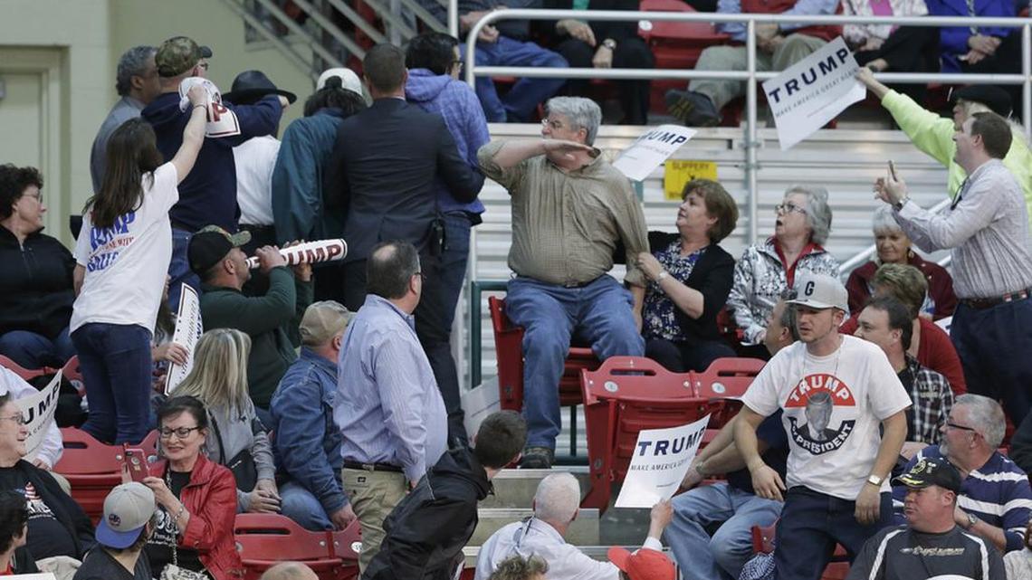 Fans react as a protester is removed from Republican presidential candidate Donald Trump’s campaign rally in Concord, NC.