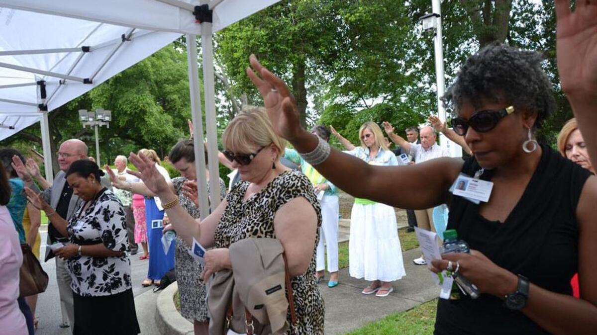 Members of the Providence Hospital community pray during a celebration of the hospital’s 75th anniversary.