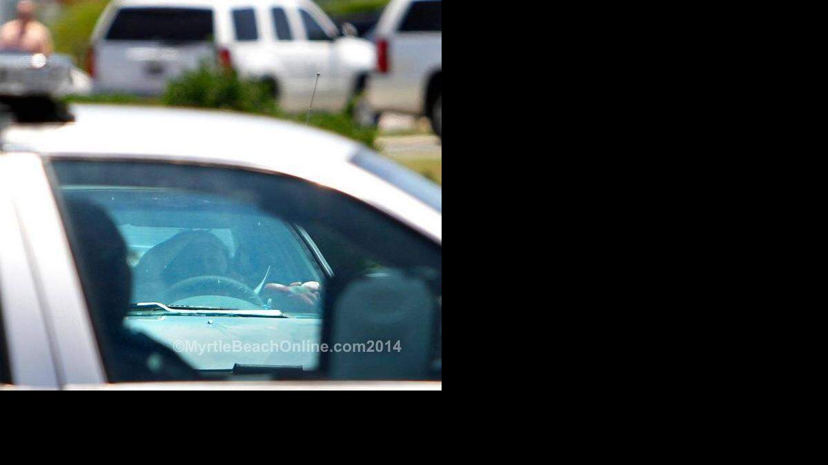 
A woman approaches an Horry County Police officer blocking Bayberry Drive and the scene of an officer-involved shooting that left a man dead in the Little River area on Thursday, June 19, 2014. 

