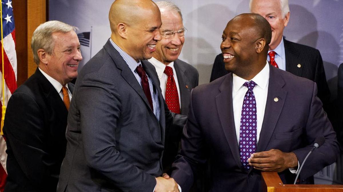 U.S. Sen Tim Scott, R-S.C., right, shakes hands with U.S. Sen. Cory Booker, D-N.J., during a news conference in Washington in October.