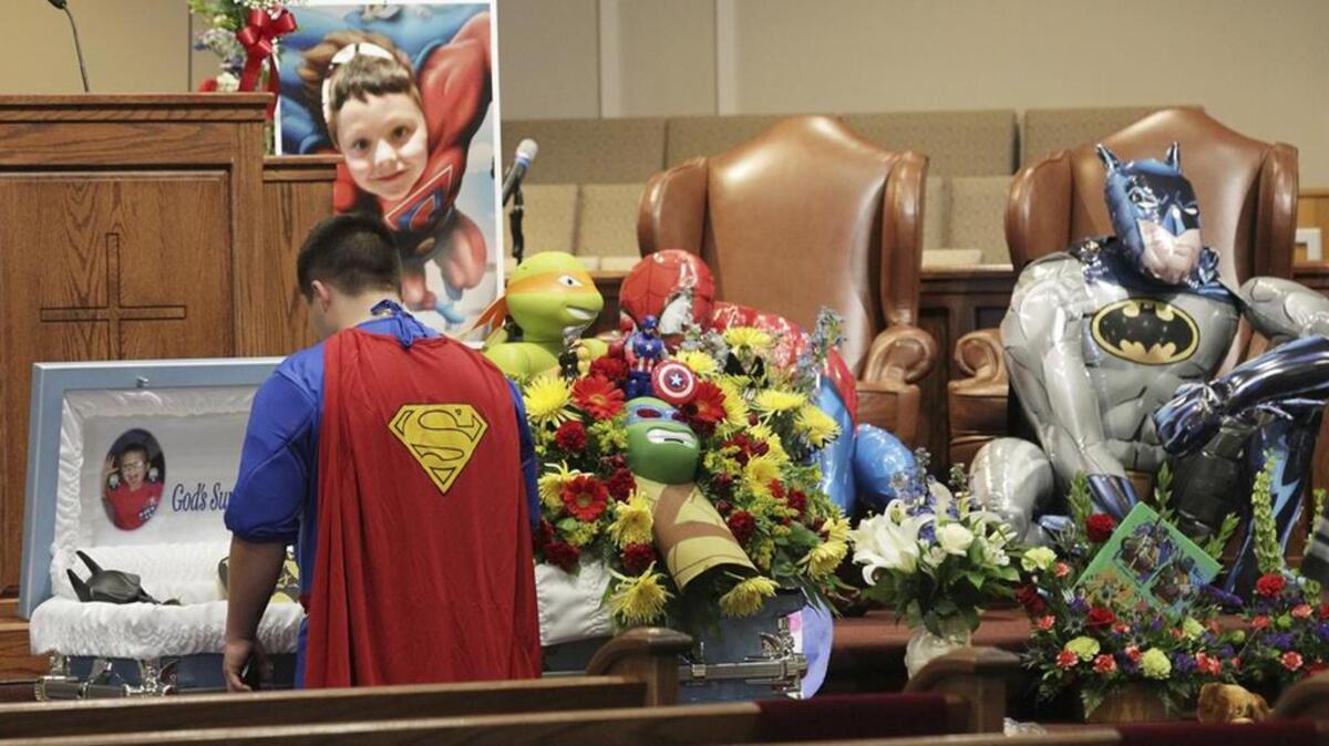 Dale Hall, dressed as Superman, stands before the casket during a superhero-themed funeral service for his brother, Jacob Hall, at Oakdale Baptist Church in Townville.
